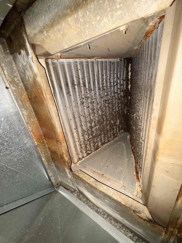 Replaced defective heat exchanger on HVAC unit under parts and labor warranty. Observed significant dirt accumulation on evaporator coils and rust formation on the metal housing during service. Removed failed component and returned to office for warranty processing.