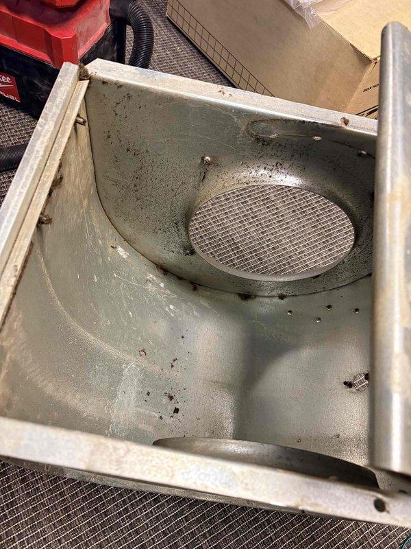 Performed blower wheel cleaning service on HVAC system which showed significant accumulation of dirt and debris in the housing compartment. Cleaned intake/exhaust vent mesh and metal surfaces to improve airflow. Inspected burner assembly during operation, confirming proper blue flame pattern and verifying all electrical connections were secure and properly functioning.