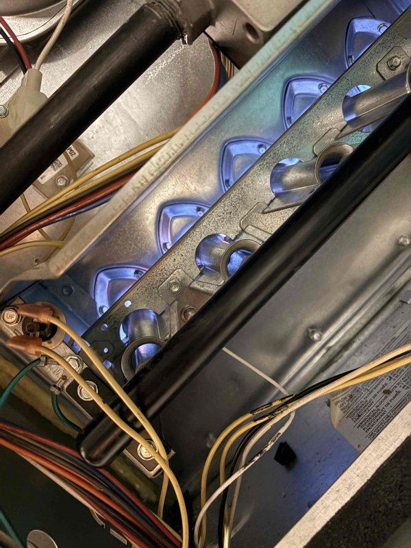 Performed blower wheel cleaning service on HVAC system which showed significant accumulation of dirt and debris in the housing compartment. Cleaned intake/exhaust vent mesh and metal surfaces to improve airflow. Inspected burner assembly during operation, confirming proper blue flame pattern and verifying all electrical connections were secure and properly functioning.