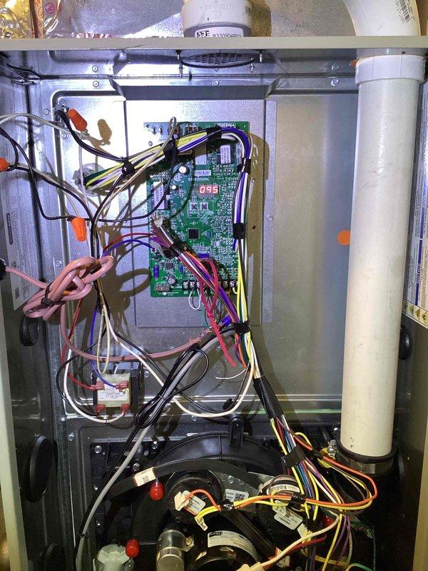 Conducted inspection of HVAC system with water damage concerns. Examined interior components including circuit board (displaying "055") and associated wiring connections. Evaluated condensate drain system and assessed coil pan area for potential silicone application as preventative measure against future water leakage.