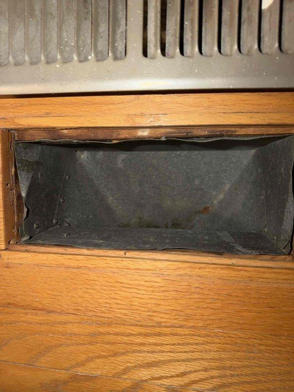 Performed comprehensive cleaning of one HVAC duct system, removing accumulated dust and debris from ventilation components. Inspected and documented areas of concern, including rust formation and structural damage (split/crack) in circular metal ductwork. System was thoroughly cleaned and photographed for documentation purposes, with special attention given to the wooden-framed rectangular return vent and metal circular duct sections.