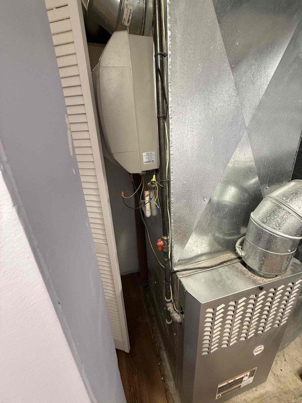 Successfully replaced Air Scrubber UV bulb in residential HVAC system located in utility closet. System includes furnace unit with connected ductwork and air handler. Documented installation with photos for service records.