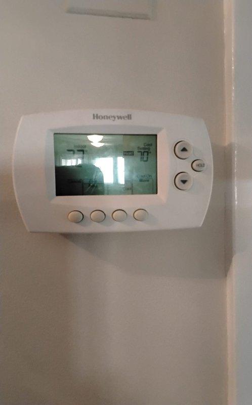 Responded to service call for unresponsive A/C system installed in 2020. Inspected Honeywell digital thermostat which displayed normal temperature readings and appeared to be functioning properly. Examined electrical connections and wiring at the equipment panel, checking terminals and connectors for proper installation and continuity.