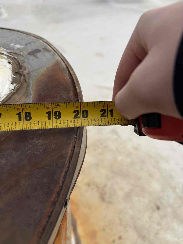 Responded to service call for water leakage affecting two top-floor units. Inspected rooftop drainage components, identified corroded circular metal fitting with visible rust and white residue. Measured component diameter (18-21 inches) and documented condition of three black cylindrical fittings with compromised honeycomb structure that were contributing to the water infiltration issue.