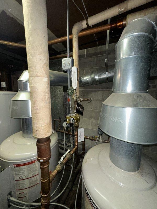 Conducted site assessment at Washington Courte Condominiums for potential replacement of existing cast iron boiler and booster pump. Inspected current NEMA Premium motor installation with associated electrical connections and documented the mechanical room configuration including water heaters, copper piping network, and PVC ventilation. Client has requested comprehensive replacement proposal for the commercial boiler system.