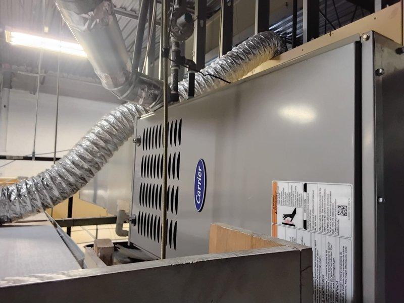 Performed routine maintenance check on Carrier commercial HVAC system (unit 106). Inspected ceiling-mounted furnace installation and associated ductwork for proper condition. Conducted electrical diagnostics using UEi G2 PHOENIX clamp meter to verify system parameters, confirming proper voltage readings and electrical performance.