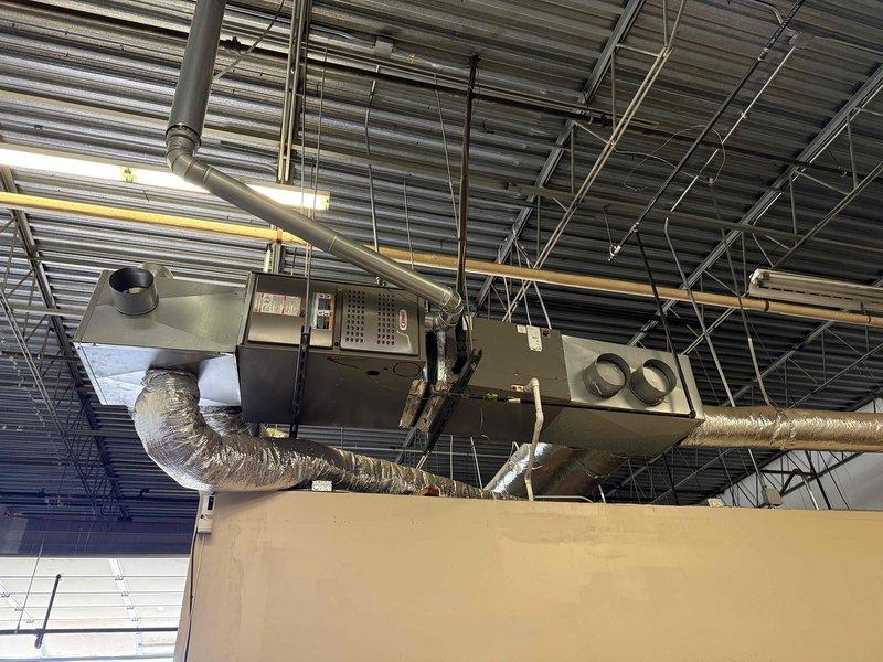 Performed routine maintenance on commercial ceiling-mounted HVAC system (AC CNC - unit 104), including inspection of the air handler, ductwork, and replacement of air filter. System is properly suspended with appropriate metal supports and all connections are secure.