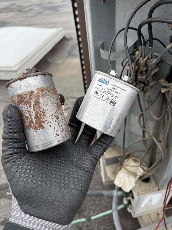 Replaced severely corroded capacitor on commercial HVAC unit with new JARD capacitor after inspection revealed significant deterioration and rust on the original component. System access panel was removed to facilitate repair work, with all electrical connections properly secured following manufacturer specifications.