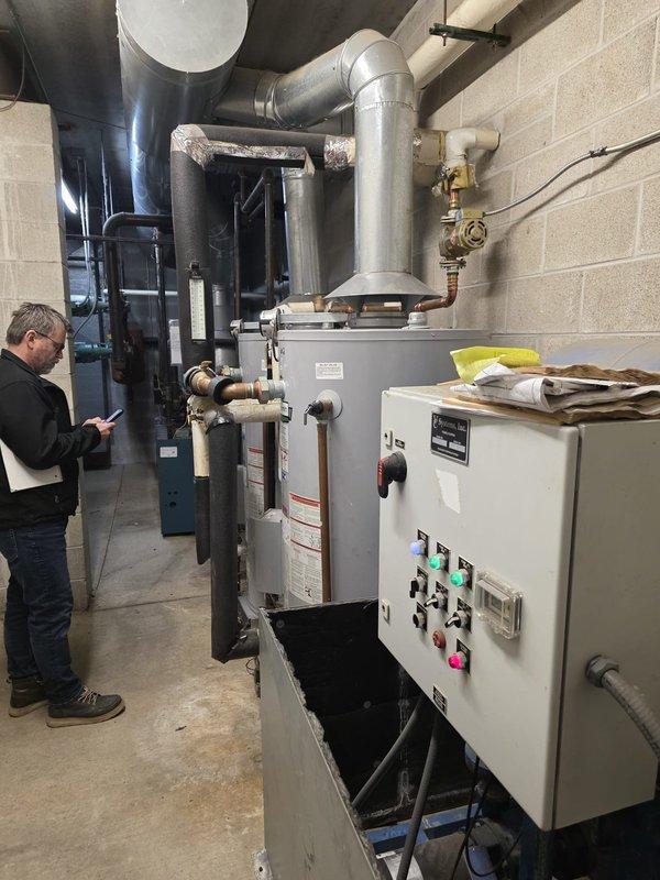 Conducted site assessment of commercial cast iron boiler system at multi-building condominium complex. Performed comprehensive evaluation of heating equipment including measurement of installation clearances and inspection of control systems, piping connections, and ventilation components. Client seeking proposals for equipment repair/replacement options to replace current service provider.