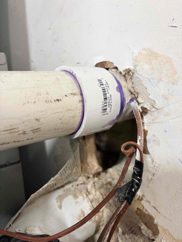 Diagnosed and documented water leak at the wall penetration of the exhaust pipe on a Rheem tankless water heater system. Observed damaged wall surface and improper sealing around the 2" PVC exhaust pipe where it enters the wall. Photos taken of the installation and leak area for documentation and repair quote purposes. Customer advised of recommended repairs and maintenance options for both water heater and furnace systems.