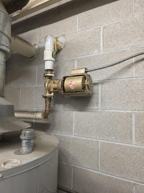 Conducted site assessment of mechanical equipment at multi-building condominium property to evaluate maintenance requirements. Inspected circulation pump system showing signs of wear, including a blue WEG pump labeled "Pump #2" and a brass hot water recirculation pump connected to PVC piping. Documented current equipment condition with photographs to prepare comprehensive maintenance proposal as requested by the board president.