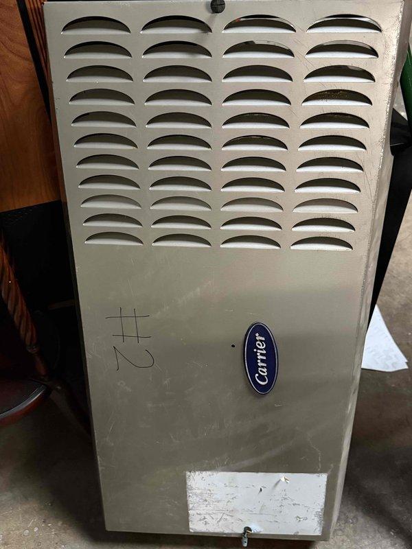 Responded to no-heat call for a 16-year-old Carrier ceiling-mounted unit not blowing air. Upon inspection of the hanging heater, found blower motor assembly had failed. Documented condition with photos for potential full system replacement recommendation due to unit age and wear.