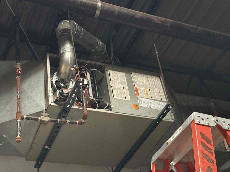 Responded to no-heat call for a 16-year-old Carrier ceiling-mounted unit not blowing air. Upon inspection of the hanging heater, found blower motor assembly had failed. Documented condition with photos for potential full system replacement recommendation due to unit age and wear.