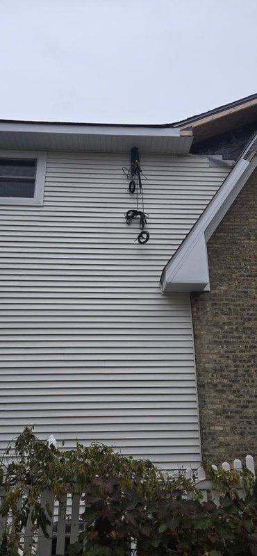 Conducted diagnostic check on residential property to assess remaining work requirements. Documented exterior condition where multiple cables are currently unsecured along vinyl siding. Verified scope of work needed to properly secure and organize wiring on exterior wall for completion of installation.