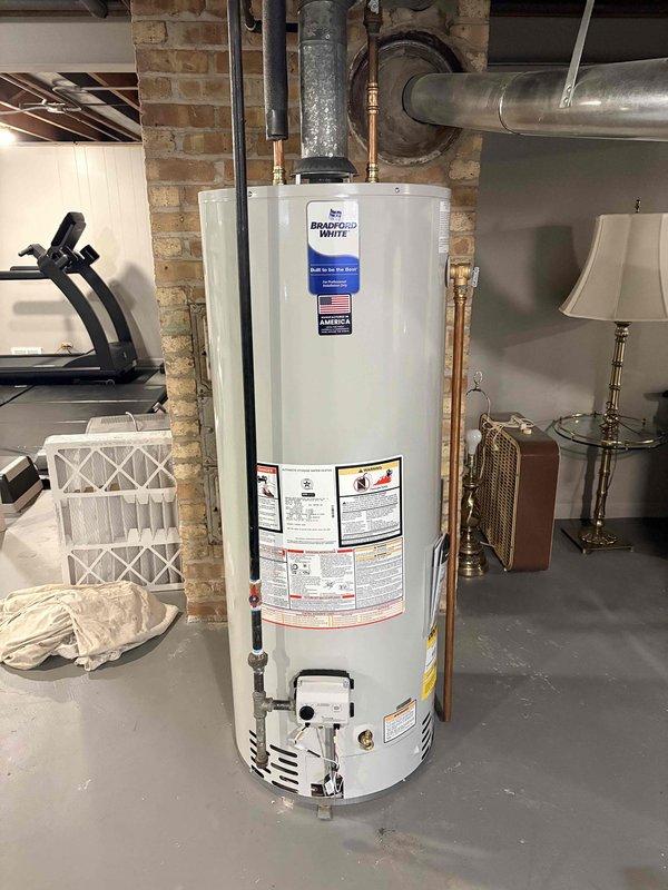 Successfully replaced existing 40-gallon water heater with new Bradford White 50-gallon model. Installed unit against brick wall in utility room, connected all necessary water lines and gas supply. Tested system for proper operation, confirming strong blue flame combustion and no leaks at connections.