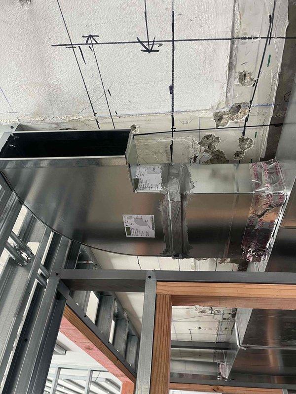 Completed installation of rectangular ductwork in commercial space per specifications, securing all sections with proper connections and labeling. Installed and wired control panel with proper terminal connections, including orange and black wiring to the primary sensor component marked "70L". All work performed according to building guidelines as marked on ceiling framework.