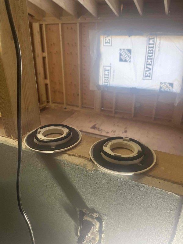 Continued Unico high-velocity air conditioning system installation in unfinished basement space, including ductwork placement and register installation. Completed system startup procedures and verified refrigerant pressures at outdoor condenser unit, with suction line reading 25.2 PSI and liquid line reading 30.2 PSI, confirming proper system operation.