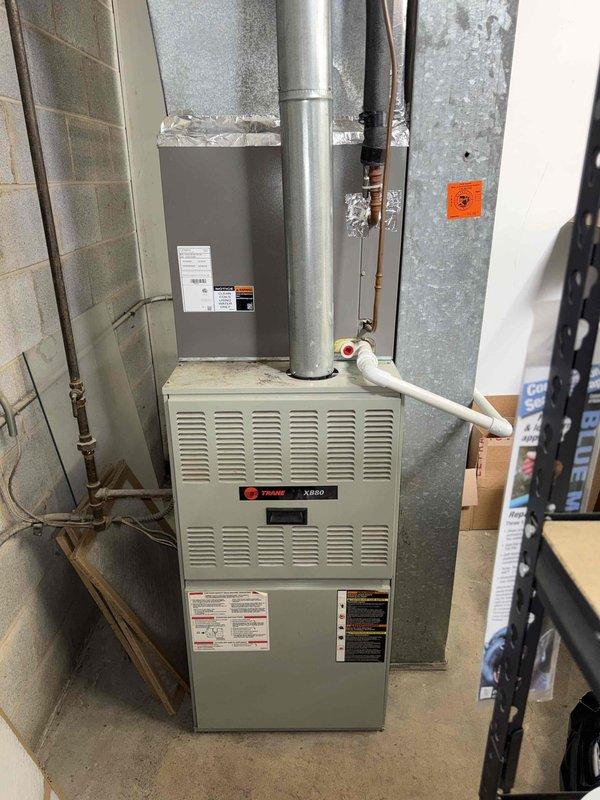 # Service Report

Completed spring preventive maintenance inspection on commercial HVAC system per prepaid service agreement. Coordinated tenant availability prior to site access as required. Performed comprehensive checklist evaluation on Trane XR80 furnace unit located in basement mechanical room, inspecting burner assembly, heat exchanger, blower motor, and all safety controls. Verified proper operation of digital control board and thermostat communication. Inspected ductwork connections, PVC condensate drainage system, and gas supply piping for leaks or deterioration.

Proceeded to outdoor condensing unit and conducted electrical diagnostics using clamp meter, recording voltage and amperage readings at 505.7 on main power supply to verify unit operating within manufacturer specifications. Inspected compressor wiring, capacitor connections, and contactor operation. All electrical components functioning properly with no abnormalities detected. Updated equipment information and filter