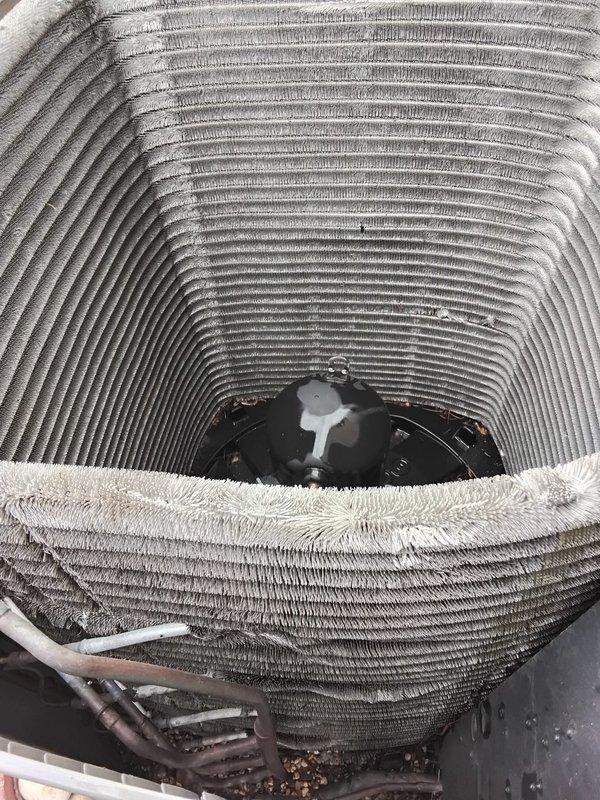 Performed comprehensive AC coil cleaning on outdoor condenser unit, removing accumulated dust and debris from the cylindrical condenser coils to restore optimal heat exchange efficiency. Leveled and stabilized the air conditioning unit using pea gravel and vibration pads as needed to ensure proper operation and prevent future mechanical stress. Temporarily relocated decorative gravel from work area during leveling process and restored landscaping materials to original position upon completion.