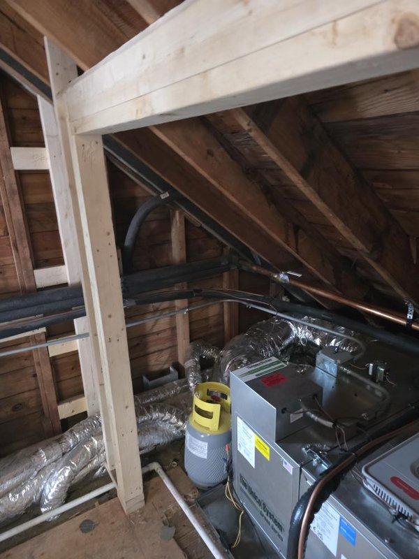 Conducted site assessment of HVAC installation in attic space of structure under renovation. Measured ceiling height clearances and evaluated existing air handler unit with connected flexible ductwork system. Documented equipment configuration, ductwork routing, and structural mounting points to verify proper installation compliance and identify any necessary modifications for optimal system performance.