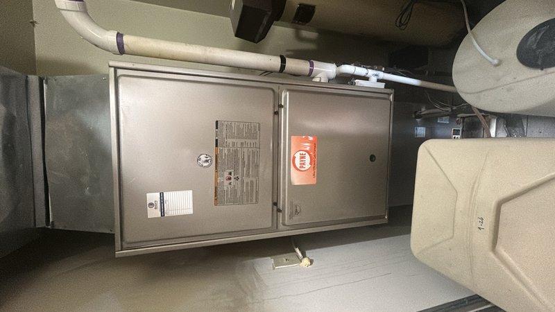 Performed comprehensive furnace inspection and evaluation for new homeowner with unknown equipment age. Assessed air handler unit, blower motor assembly, flexible duct connections, and condensate drainage system. All major HVAC components including the tan-colored air handler cabinet, silver blower assembly, PVC drain lines, and associated ductwork were inspected for operational status and code compliance.