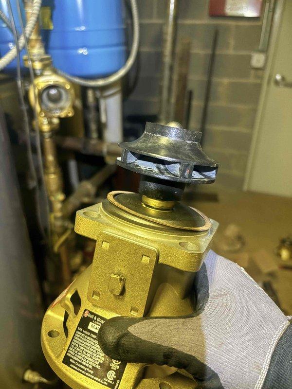 Completed warranty service on domestic hot water circulator pump. Replaced failed bearing assembly on gold-colored DHW circulator due to significant impeller wear and material degradation. Removed defective bearing assembly and returned component for warranty processing per manufacturer requirements.