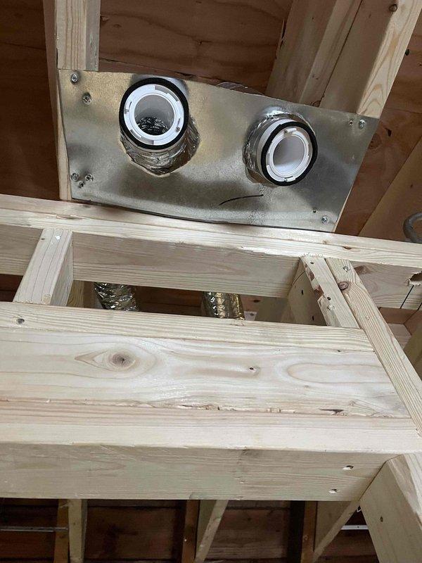 Completed warranty callback on third-floor HVAC installation to address ductwork and drainage issues. Rotated sheet metal supply duct support plate for master bedroom to provide proper clearance for finished vent cover installation, added securing plates to all third-floor supply vents with positioning verified for post-drywall finish work, and repositioned 3/4" PVC condensate drain line with proper pitch and secured to framing at elbow transition point to ensure adequate drainage.