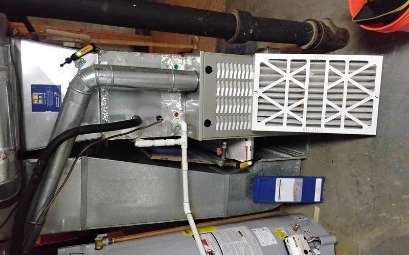 Completed spring clean and check maintenance on two air conditioning systems per comfort plan agreement. Replaced Glasfloss air filters on both units, with AC1 dating from 2004 and AC2 from 2017. Performed comprehensive inspection of furnace/air handler unit, ductwork connections including curved metallic elbows and black flexible ducts, verified proper operation of blue control components, and checked all associated piping and PVC connections. Updated equipment list with accurate system ages and specifications for service records.