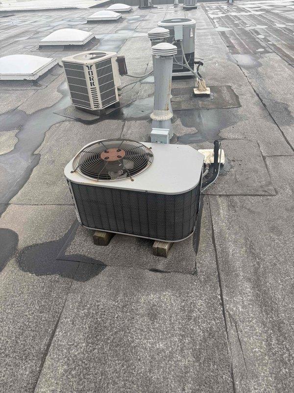 Completed spring preventive maintenance on commercial rooftop HVAC unit per contracted service agreement. Performed comprehensive inspection of electrical components, capacitor, refrigerant connections, and mechanical systems with access panel removed. Documented equipment conditions, verified operational parameters with gauges, cleaned interior compartment of accumulated debris, and captured updated equipment information and filter specifications for maintenance records.