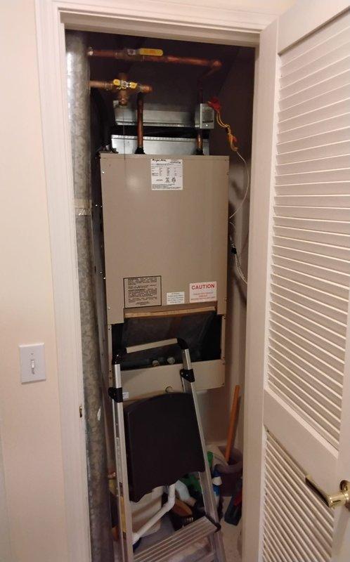 Responded to no cooling complaint on residential air conditioning system. Upon inspection, accessed HVAC unit in utility closet and examined blower motor assembly and internal components. Diagnosed system malfunction, noting that customer had previously attempted thermostat battery replacement without resolution. Documented equipment information and captured photos of furnace/air handler cabinet interior showing blower wheel, motor housing, wiring connections, and associated ductwork and plumbing connections.