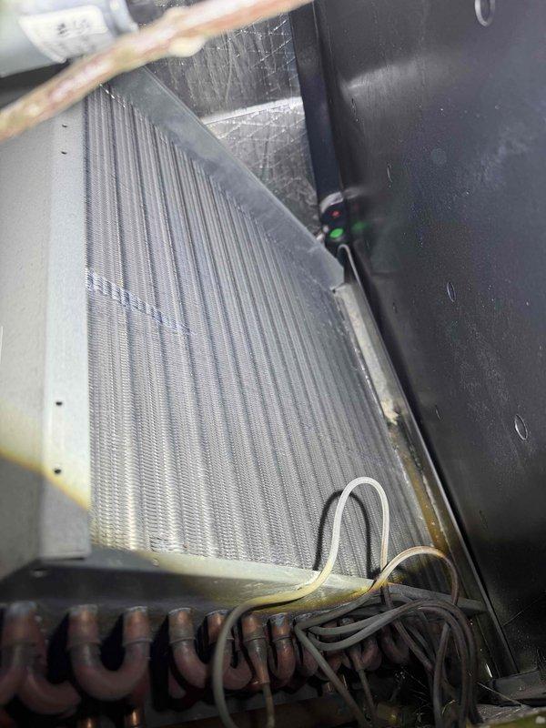 # Evaporator Coil Cleaning

Performed comprehensive cleaning of the indoor evaporator coil, which exhibited significant accumulation of dust, dirt, lint, and debris between the metal fins. Accessed the air handler unit and thoroughly cleaned the coil surfaces to restore proper airflow and heat transfer efficiency, removing visible contamination and buildup that was restricting system performance.