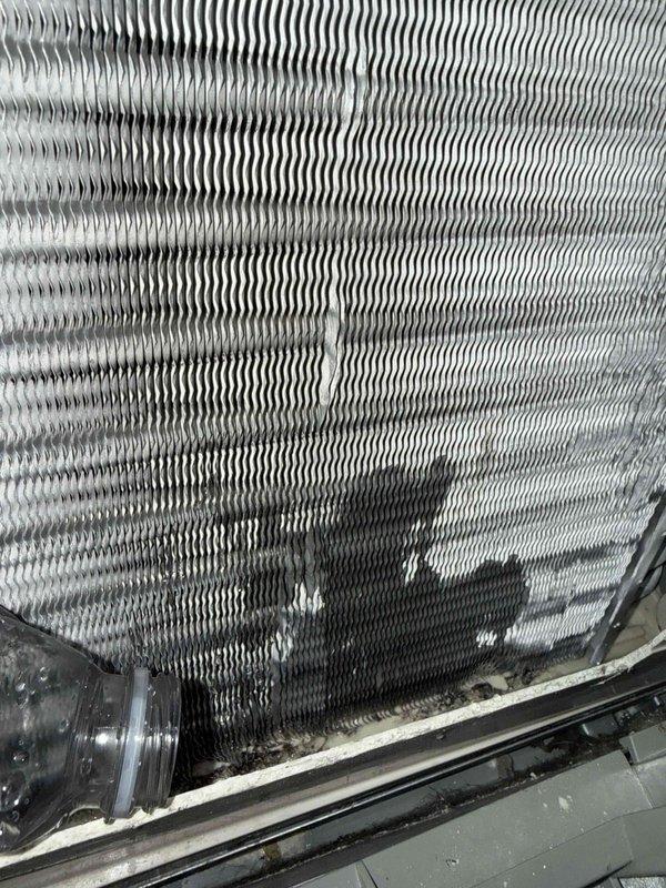 Completed spring clean and check on residential air conditioning system per comfort plan maintenance agreement. Performed comprehensive inspection of outdoor condensing unit, cleaned evaporator coil showing moderate dust and debris accumulation between fins, verified refrigerant line connections, and confirmed proper unit operation. Reminded customer of pending estimate for attic fan replacement, with original unit currently stored at shop.
