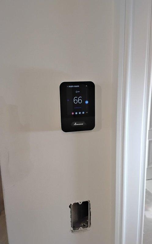 Continued troubleshooting thermostat connectivity issues in commercial mechanical room. Assessed Amana thermostat displaying 66 degrees in cooling mode and verified proper communication with HVAC system. Documented equipment installation including tankless water heaters, ductwork, and control systems to identify potential interference sources affecting thermostat network connectivity.