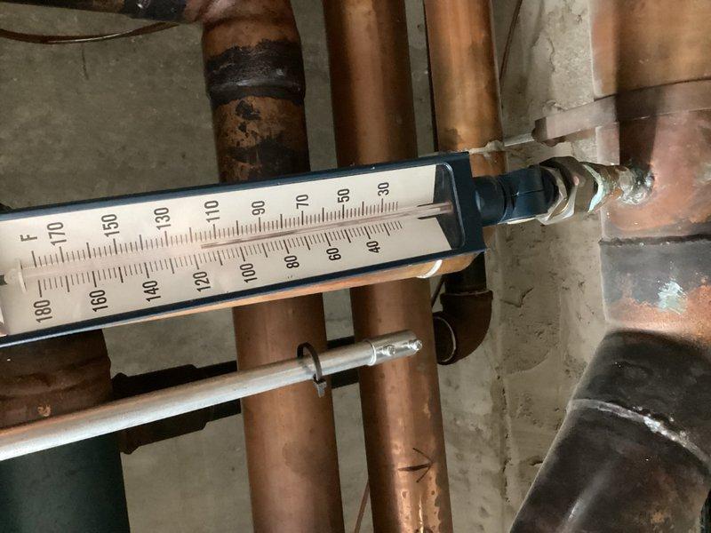Responded to callback for no heat condition in commercial building with heating system failing to activate below 50°F setpoint despite two previous service visits. Inspected boiler system, copper supply and return piping, zone valves, and thermostat controls mounted on mechanical room wall. Verified temperature gauge readings on main distribution lines and checked all blue-handled isolation valves for proper operation. System diagnostics performed to identify root cause of heating failure and determine necessary corrective action for reliable operation.
