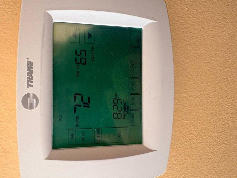 Completed annual clean and check maintenance on Trane air conditioning system per Comfort Plan agreement. Performed comprehensive inspection of outdoor condenser unit including coil cleaning, electrical connection verification, refrigerant level assessment, and fan motor operation check. Verified thermostat operation and calibration showing system cooling properly with setpoint at 63°F and ambient temperature reading 72°F. All components found operating within manufacturer specifications with no deficiencies noted at time of service.