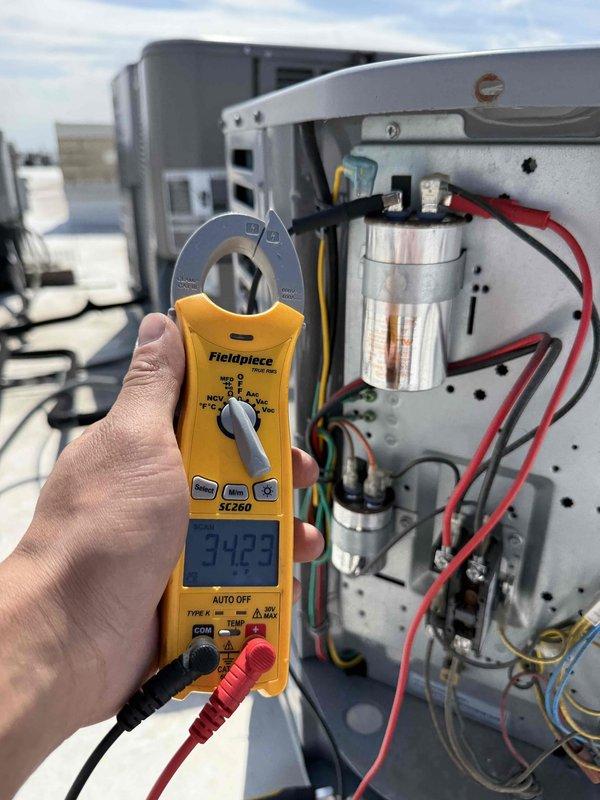 Performed preventive maintenance inspection on commercial rooftop HVAC unit per service agreement. Connected manifold gauges to measure refrigerant pressures and used clamp meter to verify electrical readings at 94.93 on system components. Inspected internal electrical components including capacitors, wiring, and connections, confirming all equipment operating within normal parameters with no deficiencies noted.