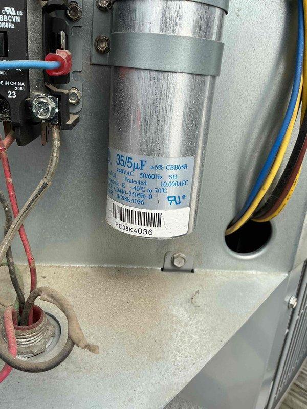 Completed commercial air conditioning clean and check per maintenance agreement. Inspected electrical components including dual-run capacitor rated at 35/5μF/440VAC, verified proper operation and connections, and performed diagnostic testing with readings showing system operating within normal parameters at 34.12 on electrical meter.