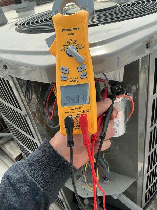Performed commercial preventive maintenance inspection per service agreement on rooftop AC unit. Conducted electrical diagnostics using clamp meter, measuring voltage and amperage readings on system components. Verified capacitor operation and tested electrical connections throughout the unit. All measurements within normal operating parameters. System operating properly with no deficiencies noted.