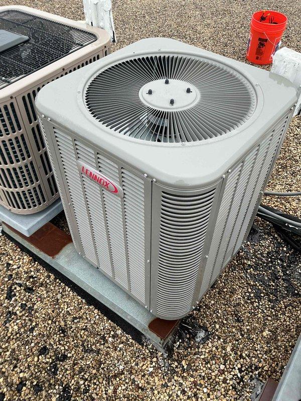 Completed comprehensive tune-up and maintenance service on rooftop-mounted Lennox air conditioning system. Performed standard preventive maintenance procedures, collected payment, and documented equipment condition with photographs showing multiple HVAC units on gravel-covered rooftop with visible weathering on mounting pads and support structures.