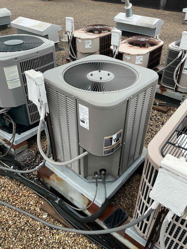 Completed comprehensive tune-up and maintenance service on rooftop-mounted Lennox air conditioning system. Performed standard preventive maintenance procedures, collected payment, and documented equipment condition with photographs showing multiple HVAC units on gravel-covered rooftop with visible weathering on mounting pads and support structures.