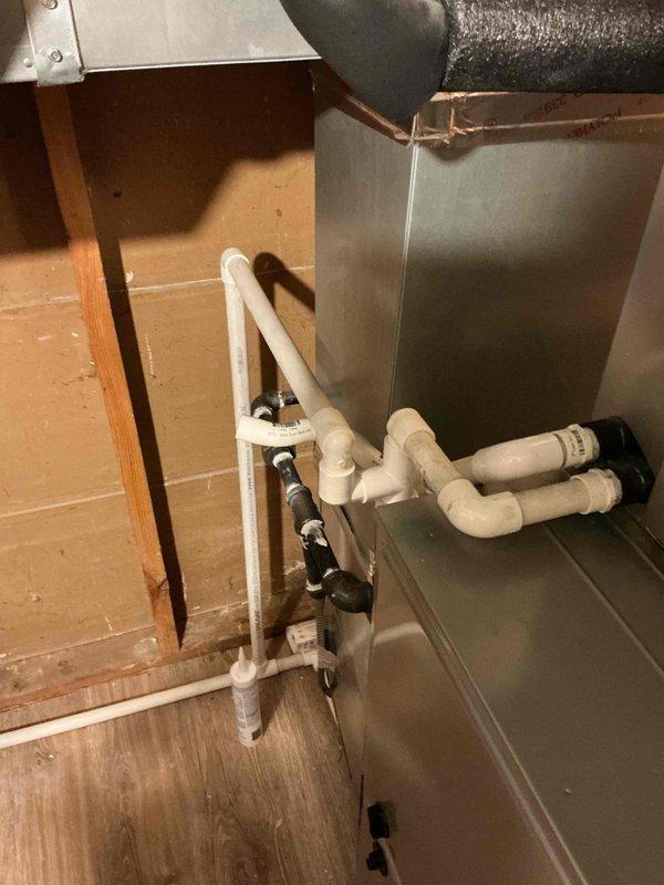 Performed comprehensive Comfort Plan clean and check maintenance on single-system residential air conditioning unit. Inspected outdoor condenser unit with protective cage enclosure mounted on concrete pad, verified proper operation and clearances. Accessed attic-mounted air handler, inspected evaporator coil assembly, checked condensate drain lines and PVC drainage system for proper flow and connections. All components operating within normal parameters, system ready for cooling season.