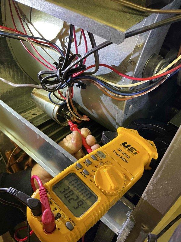 Completed comprehensive tune-up and inspection on single-zone residential HVAC system including outdoor condenser unit and indoor air handler. Performed electrical diagnostics with digital multimeter, verifying proper voltage readings at control wiring connections and testing system components for optimal performance. Inspected exterior condenser unit mounted on gravel pad, confirmed adequate airflow through ventilation slots, checked refrigerant line connections, and verified proper operation of all mechanical components.