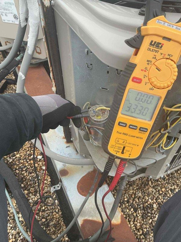 Completed routine tune-up maintenance on rooftop HVAC system, performing comprehensive diagnostics on air conditioning and air handler unit. Utilized digital clamp meter and gauges to verify electrical parameters, measure amperage draw, and check temperature readings on system components including capacitor. System found to be clean and correct, with all components operating within normal specifications.