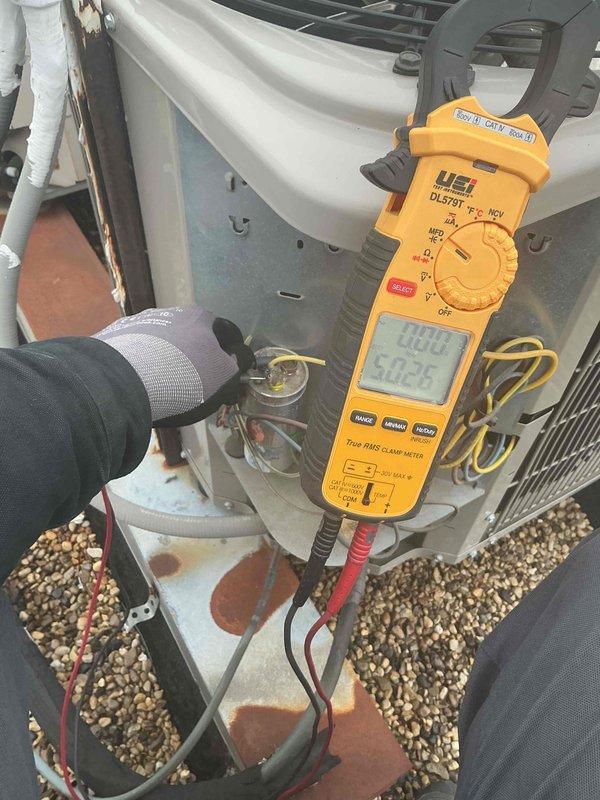 Completed routine tune-up maintenance on rooftop HVAC system, performing comprehensive diagnostics on air conditioning and air handler unit. Utilized digital clamp meter and gauges to verify electrical parameters, measure amperage draw, and check temperature readings on system components including capacitor. System found to be clean and correct, with all components operating within normal specifications.