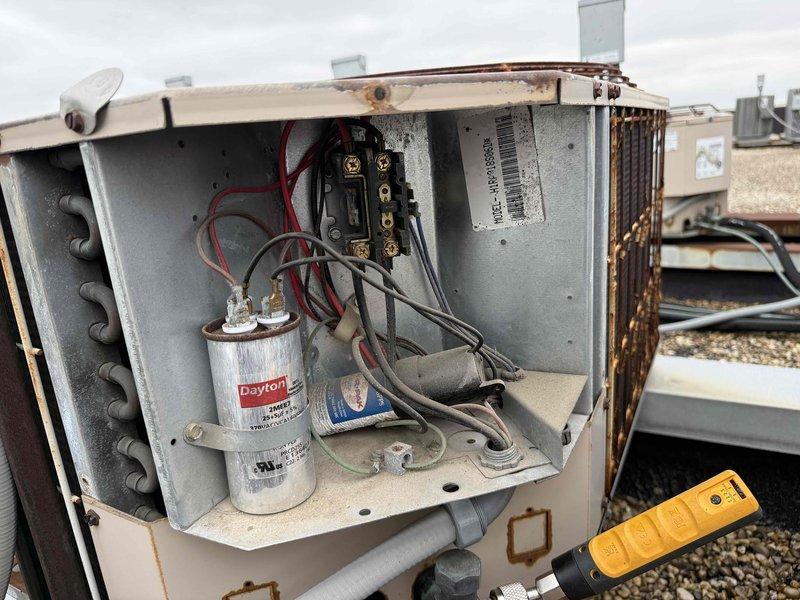 Performed comprehensive tune-up and diagnostic evaluation on rooftop HVAC system serving single zone. Conducted electrical testing using digital multimeter, verifying capacitor operation and measuring voltage readings at evaporator coil assembly. Noted significant deterioration and corrosion on condenser coil with heavy oxidation throughout finned surfaces, which will impact system efficiency and heat transfer capability. Collected service fee and documented equipment condition with photographic evidence for customer records.