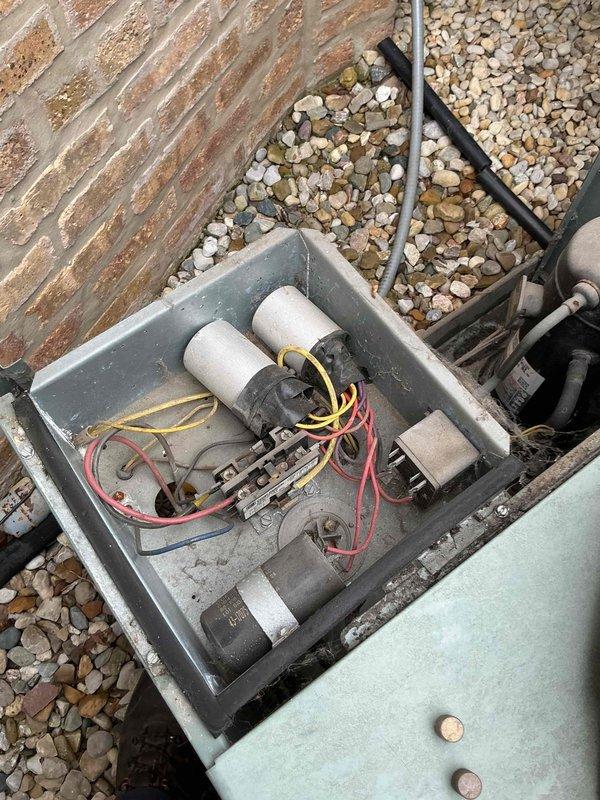 Responded to no-cool complaint on 15+ year old split system. Upon arrival, confirmed indoor blower operational and heating mode functional, but outdoor condensing unit failed to energize when thermostat called for cooling. Performed visual inspection of outdoor unit and found severely weathered equipment with significant corrosion on cabinet and mounting bracket. Removed electrical access panel and diagnosed failed dual-run capacitor with visible bulging and discoloration. Tested contactor operation and verified proper thermostat signal at low-voltage terminals. Replaced defective capacitor with appropriate microfarad-rated component, secured all electrical connections, and restored power to system. Cycled unit through complete cooling operation and confirmed compressor and condenser fan motor startup with normal amperage draw. System now cooling properly with adequate airflow and refrigerant pressures within manufacturer specifications.