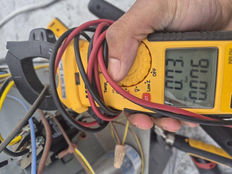 Completed comprehensive tune-up on single-system rooftop HVAC unit, performing standard maintenance protocol including filter replacement and system diagnostics. Utilized digital multimeter to verify electrical readings on capacitor and related components, confirming proper system operation. Collected payment as requested and documented equipment condition with photos showing outdoor condensing unit and electrical measurements.