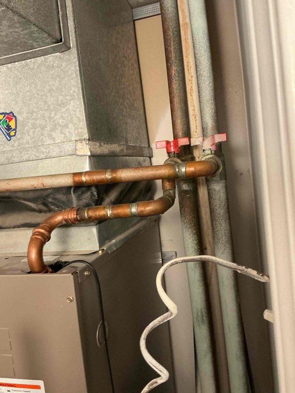 Completed return visit to address unwanted warm air discharge from HVAC system. Located and closed isolation valves on heating system piping to prevent hot water circulation to air handler during cooling season. Verified proper valve operation and confirmed no heat transfer occurring through system after valve closure. Customer concern resolved.