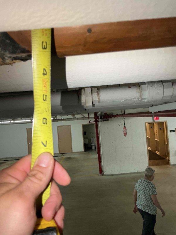 Responded to emergency water leak call in commercial building garage area affecting heating system piping leading to boiler room. Upon arrival, coordinated building access and conducted thorough inspection of the overhead piping infrastructure. Located source of leak at corroded copper pipe joint showing extensive green patina, verdigris buildup, and surface deterioration from prolonged moisture exposure. Documented pipe measurements and corrosion damage with photographs for repair assessment. The affected heating pipe joint exhibited severe oxidation and mineral deposits requiring replacement rather than simple repair due to extent of deterioration.