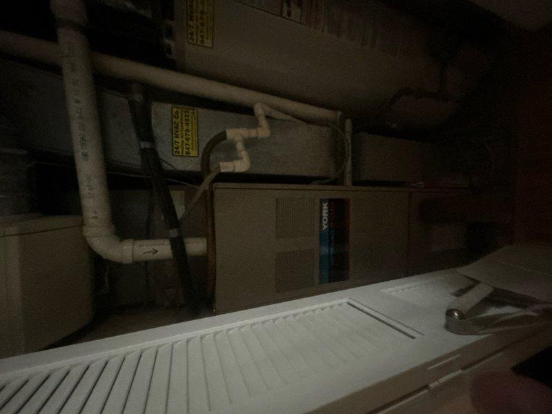 Responded to service call for AC unit cycling on and off with inadequate cooling. Upon inspection of the HVAC system located in the utility space, assessed the air handler, associated ductwork, and mechanical components. Evaluated system performance and determined that repair was not economically viable given the age and condition of the equipment. Provided comprehensive estimate for complete system replacement including new air handler unit, condenser, refrigerant lines, and necessary electrical connections. Documented existing installation configuration including access panel locations and current equipment setup through photographic records to facilitate accurate replacement specifications.